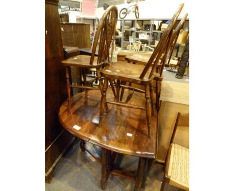 OAK DINING TABLE AND CHAIRS. Oak dropleaf dining table and four wheel back chairs