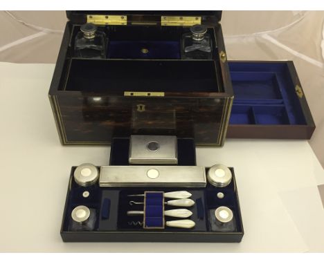 A 19th century coromandel and brass-bound vanity case set by Lund of Cornhill, London with silver set bottles boxes and mothe
