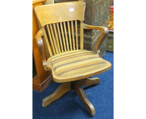 An early 20th century oak comb back swivel desk chair, 81cm high x 58cm wide x 60cm deep, a bergere armchair and an upholster