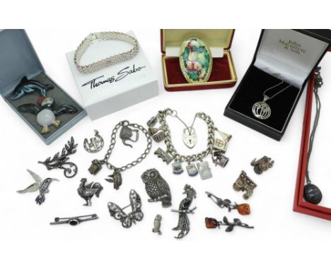 A collection of silver and marcasite brooches to include an owl and a rooster, two silver charm bracelets to include Georg Je