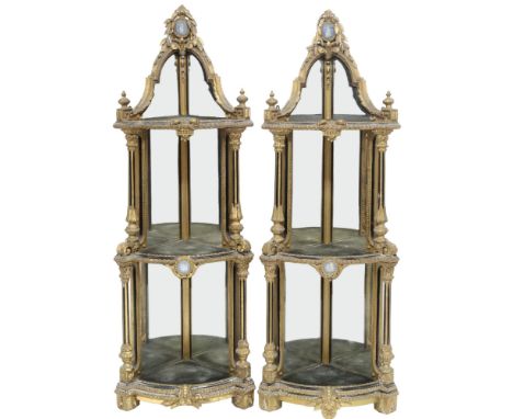 A PAIR OF 19TH CENTURY LOUIS XV STYLE GILT GESSO MIRROR BACKED CORNER WHAT-NOTS each capped with ceramic plaque within acanth