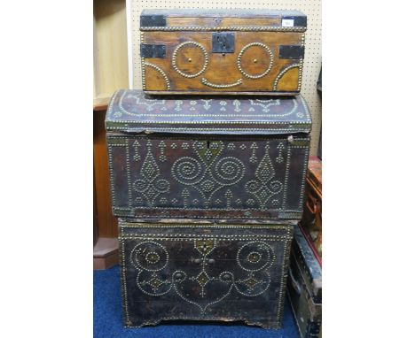 A lot comprising a large hide bound travel trunk with studded decoration, another hide bound dome top travel trunk and a smal