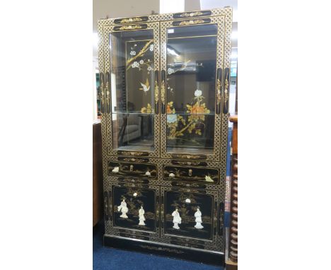 A 20th century Oriental style black lacquer display cabinet with pair of glazed doors over two short drawers and pair of cabi