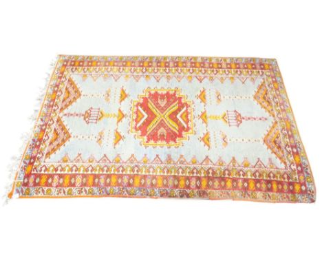 A light blue ground Caucasian rug with red geometric central medallion on geometric patterned ground within multiple multicol