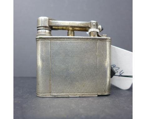 A silver Dunhill novelty compact modelled in the form of a lighter, having engine turned decoration, with mirrored interior, 