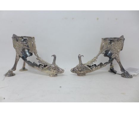 A pair of silver plated cornucopia stands, modelled as goats, missing glass slips, H.13 L.18cm, together with a silver plated