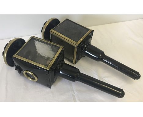 A pair of vintage carriage lamps with makers mark inside. Left and right hand lamps. Painted black with gilt decoration. 