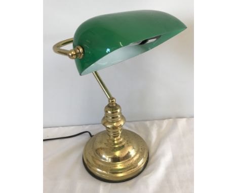 A brass based reading desk lamp with green glass shade.  