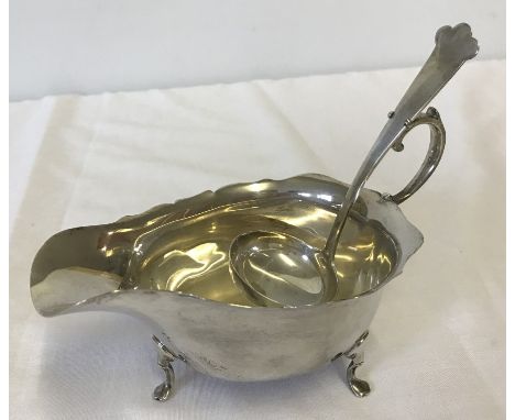 A silver sauce boat and ladle Hallmarked Birmingham 1915 and Birmingham 1916.  