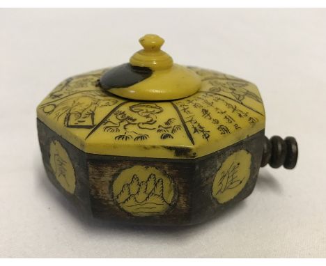 A Chinese travelling inkwell, c.19th century. Octagonal shape with carved decoration. Approx 7cm across.