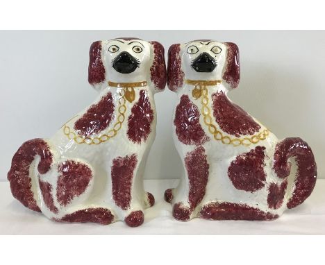 A pair of large Staffordshire flat back ceramic fire dogs. Of pink and cream colouration Approx. 32cm tall.