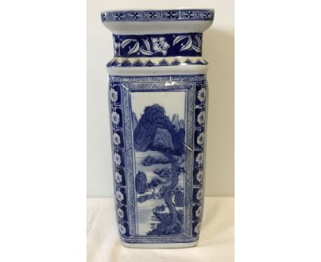 A square shaped oriental blue and white ceramic stick stand / vase. With decorative panels to each side. Stands on a base. Ap