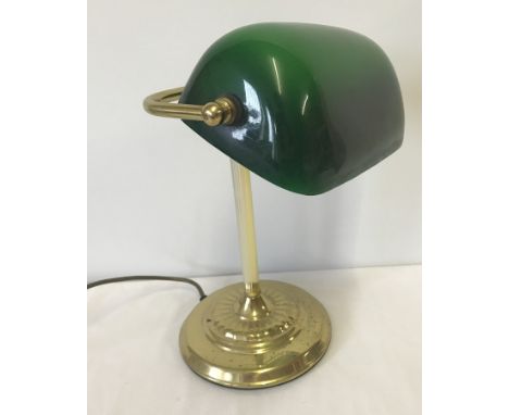 A brass based bankers style desk lamp with green glass adjustable shade.  