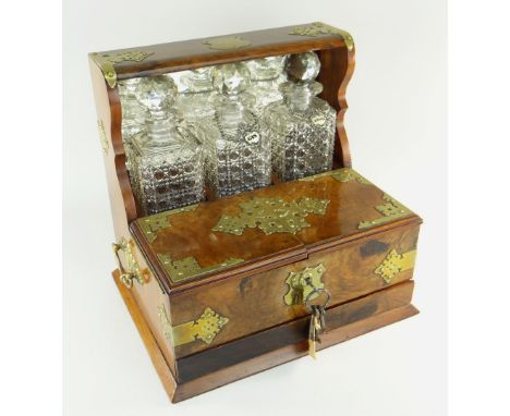 VICTORIAN BRASS BOUND WALNUT BOX TANTALUS, c. 1880, containing three cut glass spirit decanters and stoppers behind box compa