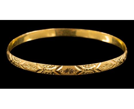A gold coloured bangle: with incised decoration, stamped '22c', 7cm wide, 15gms.