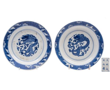 A pair of Chinese blue and white 'dragon' saucer dishes: each painted with a scaly dragon persuing a flaming pearl within lin