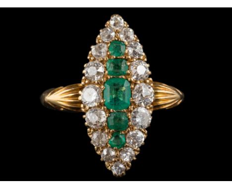 An 18 carat gold, emerald and diamond marquise-shaped cluster ring: with central row of graduated emeralds within a surround 