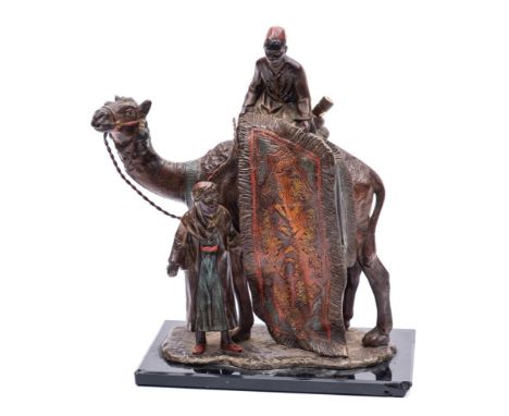 An Austrian cold painted spelter style table lighter: modelled as an Arab carpet seller with camel, his assistant holding the