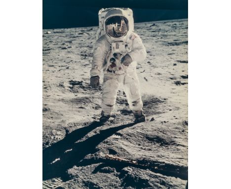 Armstrong (Neil) Buzz Aldrin with the reflection of his shadow, the lunar module, the U.S. flag and Armstrong in his convex g