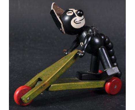 A small vintage German made Felix The Cat on a scooter. Jointed wooden body with leather ears and white ' Felix ' painted to 