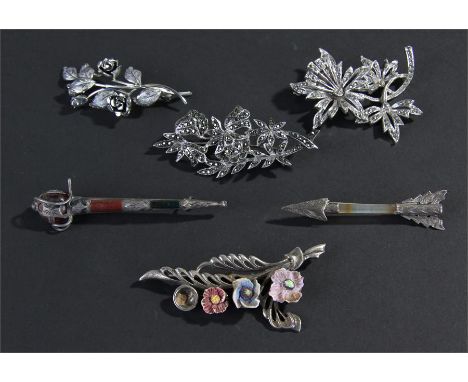 Silver brooches, to include a Scottish agate set sword example, an agate arrow example, two flower head examples and two marc