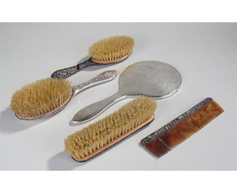 Silver dressing table mirror, Birmingham 1942, together with three silver handled brushes and a comb, (5)