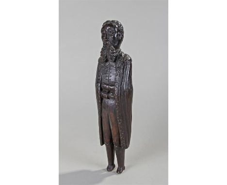 18th Century oak carved figure of a gentleman, the bearded figure with a deep collar, buttoned shirt and long cloak, arms cro