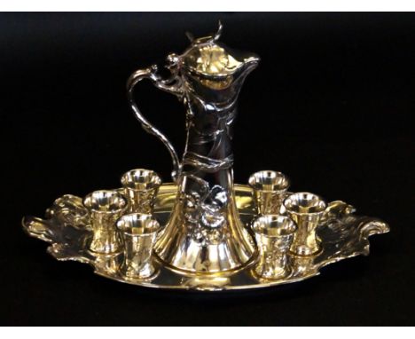 An Art Nouveau silver-plated drinking setComprising jug, six shot glasses and oval tray, each having cast floral decoration, 