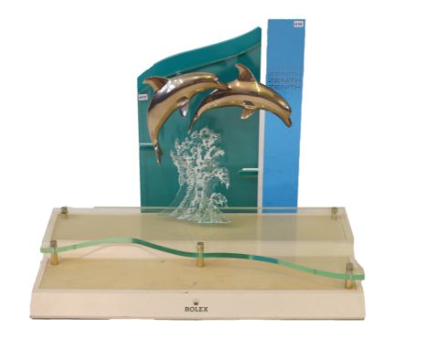 A vintage Rolex Zenith shop display standModelled with two metal leaping dolphins above Perspex panel and wooden plinth base,