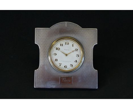 An Art Deco hallmarked silver framed desk clockHaving engine turned silver decoration with stained wooden back, the dial mark