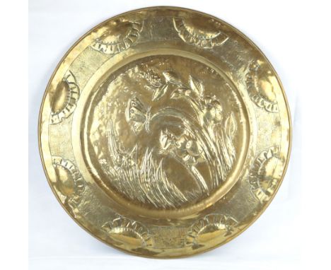 A large Arts & Crafts brass wall chargerRepousse decorated with butterflies in landscape scene, (unmarked), diameter 68cm    