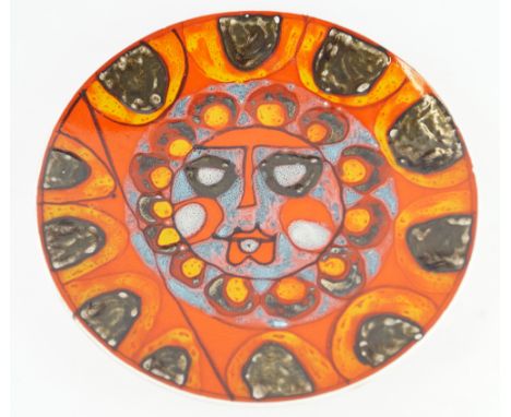 A Poole Pottery Delphis range chargerOf circular form, decorated with a central sun face, painted in shades of red, orange, b