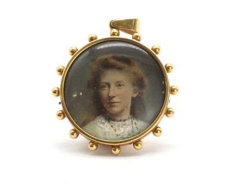 A Victorian gold mounted miniature portrait pendant,the painted miniature depicting head and shoulders of a young woman, belo