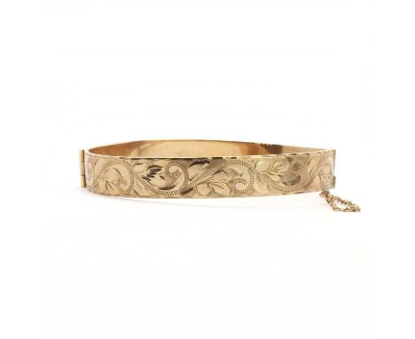 A 9ct gold hinged bangle,a flat section bangle with engraved front and plain back, oval in shape, to hinge, safety chain and 