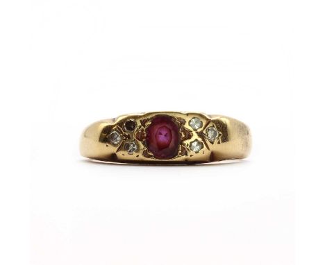 A gold ruby and diamond carved head ring,an oval mixed cut ruby grain set to the centre, with eight cut diamond points on eac