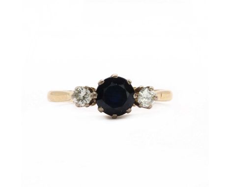 An 18ct gold three stone sapphire and diamond ring,a round mixed cut sapphire with a round brilliant diamond on either side, 