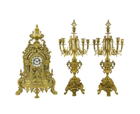 An ornate Continental brass clock garniture. 20th century, the movement striking on a bell, with twin six light candelabra, h