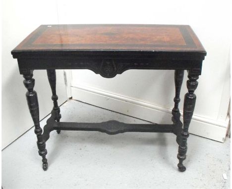 A late 19th century ebonised card table on turned legs, joined by a stretcher, 88cm wide.