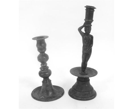 A figural candlestick, 28cm high, and a pewer candlestick 19cm high. 