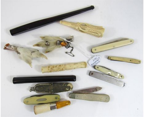 A silver and mother of pearl fruit knife and other pen knives, cigarette holders, and two claw brooches 