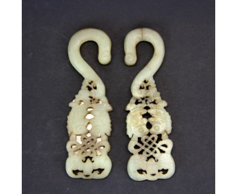 A pair of Chinese carved nephrite jade hooks decorated with fish, H. 10cm.