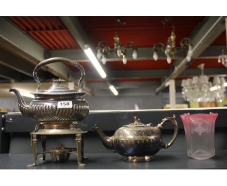 A silver plated spirit kettle and teapot with a Edwardian lamp shade.