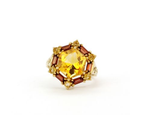 A 9ct yellow gold ring set with a fancy hexagonal cut citrine surrounded by baguette cut garnets and round cut citrines, (O.5