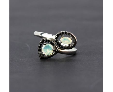 A 925 silver crossover ring set with opals and black spinels, (R ).