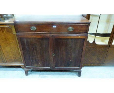 A George III mahogany press cupboard, the pair of drawers enclosing two sliding trays under a frieze drawer on bracket feet. 