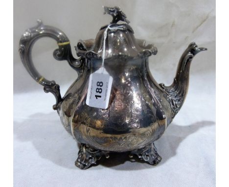 A Victorian silver teapot with flower head finial, foliate chasing and armorials. London 1856. 26ozs