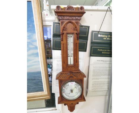 ANEROID BAROMETER AND THERMOMETER ON A CARVED OAK MOUNT