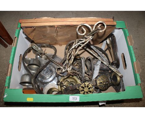 A box of miscellaneous metal ware to include horse brasses, vintage Saab hub cap, two military coloured prints etc.