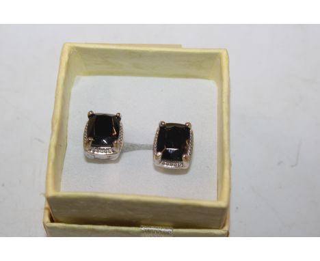 A pair of sterling silver stud earrings with EMF protection button inset