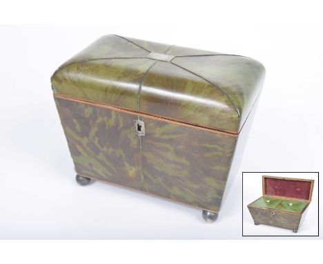 A regency green tortoiseshell tea caddy Of sarcophagus form, rising from four ball feet, to a domed cover, applied with white